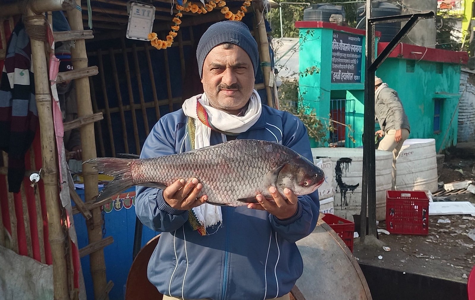 A shopkeeper is showcasing Catla fish at the wholesale fish market of Patna Bihar Bazaar Samiti.
